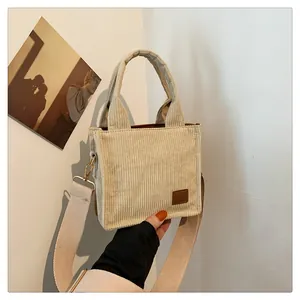 Detail der beigen Cord-Mini-Handtasche mit Lederpatch und verstellbarem Stoffriemen