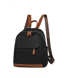 Side view of lightweight black Oxford fabric backpack with brown synthetic leather accents