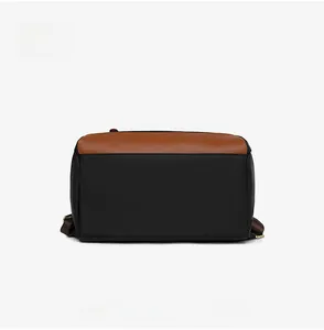 Detail view of the durable Oxford fabric and brown leather base of the commute backpack