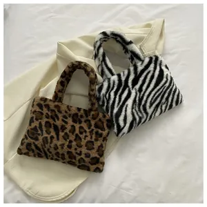 Detail showing plush leopard and zebra faux fur handbags on textured fabric background