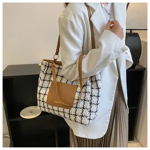 Gros plan sur le cabas en tweed à carreaux noir et blanc avec bandoulière en cuir marron