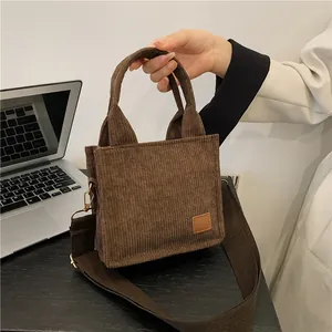 Mini-Handtasche aus braunem Cord mit breitem Umhängegurt in einer Lifestyle-Umgebung
