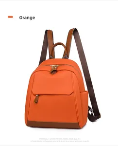 Detail of orange Oxford fabric backpack with front metal zipper and adjustable straps