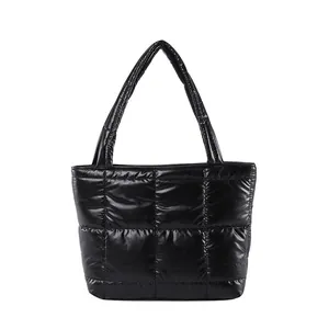 Quilted black puffer tote bag for women with padded top handles and a shiny nylon finish