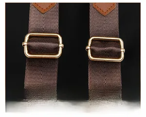Detailed view of adjustable dark brown woven shoulder straps with gold metal buckles