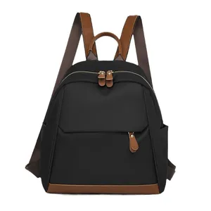 Classic black oxford cloth backpack with brown leather trim and golden hardware