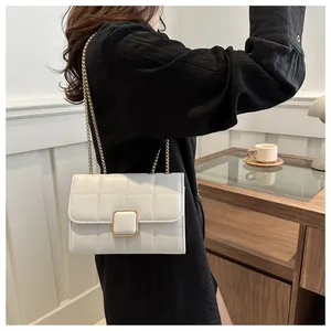Détail du sac à bandoulière en similicuir blanc matelassé avec fermoir doré et chaîne