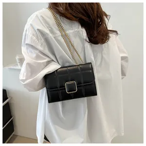 Détail du sac bandoulière matelassé noir avec fermoir carré doré et bandoulière chaîne