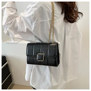 Détail du sac bandoulière en cuir matelassé noir avec fermoir doré et bandoulière chaîne