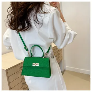 Detail of woven texture lime green leather handbag with gold twist lock and handle