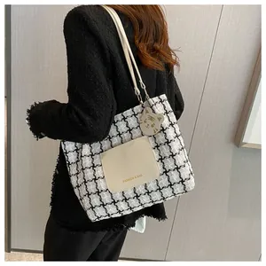 Détail du sac cabas à carreaux avec poche avant beige et charmant pendentif tigre