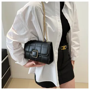 Gros plan d'un sac bandoulière matelassé noir avec chaîne dorée sur un mannequin