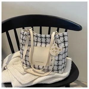 Détail du sac cabas à carreaux avec un joli pendentif chat doré et poche en cuir chic