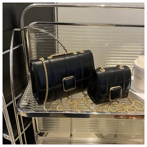 Gros plan de sacs bandoulière noirs matelassés avec chaînes dorées et fermoirs carrés