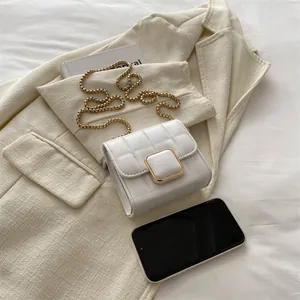 Petit sac blanc matelassé avec bandoulière chaîne dorée et fermoir carré sur veste