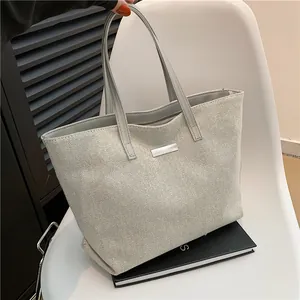 Large capacity canvas tote bag with woven texture on a white chair, minimalist casual style