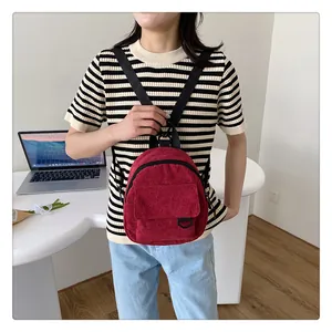 Detalle de la textura de la mini mochila de pana burdeos y bolsillo con solapa frontal