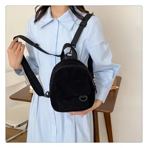 Detalle de la textura de la mini mochila de pana negra con correas de nailon ajustables