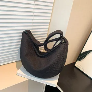 Chic black crescent crossbody bag with quilted bubble texture and adjustable strap