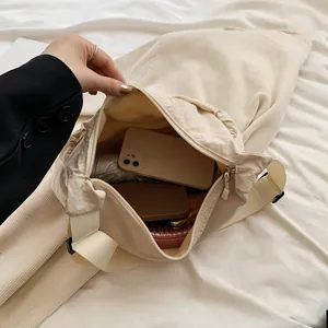 Chic beige crescent tote bag with adjustable shoulder strap and spacious interior