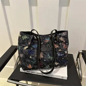Black canvas tote bag for women featuring colorful butterfly embroidery and long shoulder straps