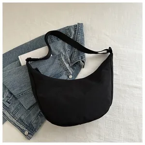 Detailoverzicht van de zwarte halve maan crossbodytas van nylon met brede schouderriem