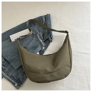 Detail van de olijfgroene hobo-tas met brede schouderriem op een witte bedachtergrond