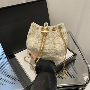 Woven straw bucket bag with floral embroidery and gold chain strap for women
