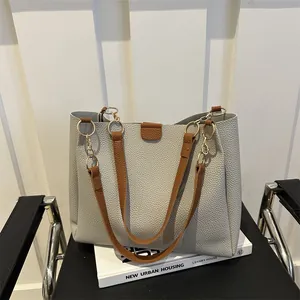 Minimalist grey large tote bag with brown contrast straps and gold metal chain details