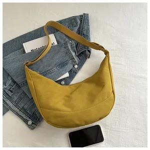 Detail van gele nylon halvemaanvormige tas met verstelbare riem en ritssluiting