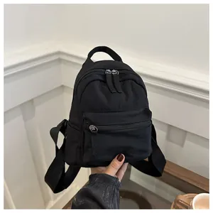 Detailed view of mini black canvas backpack with durable fabric and long zipper pullers