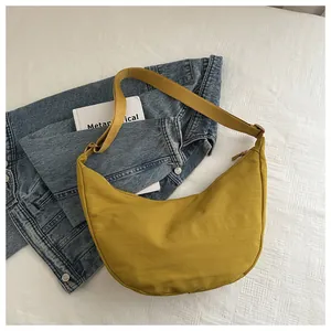 Detail van de mosterdgele hobo tas op ruitjespatroon met boek en spijkerjasje