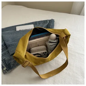 Binnenkant van gele canvas tas met ruimte voor boeken, paraplu en een telefoon