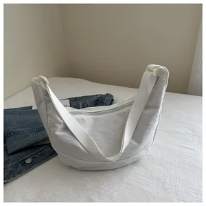Detail van de witte nylon halve maantas met gerimpelde textuur en de verstelbare riem