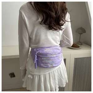 Detail of light purple waist bag featuring colorful geometric embroidery and textured fabric