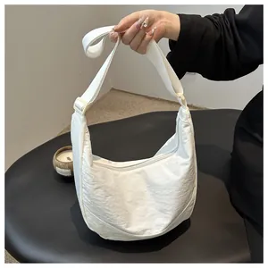 Detail van de witte nylon halve maan tas met textuur en verstelbare schouderriem