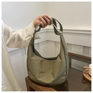 Detail van legergroene nylon halve maantas met verstelbare riem en ritssluiting
