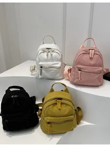 Mini canvas backpack for women in black, white, pink, and yellow colors