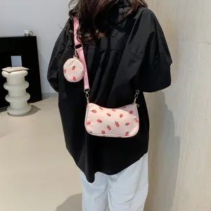 Bolso bandolera de pana rosa con estampado de fresas y un pequeño monedero redondo