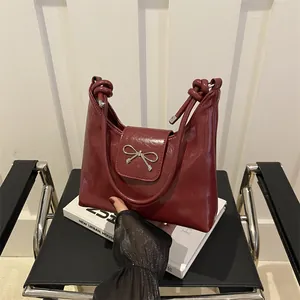 Sac seau en cuir verni bordeaux avec nœud métallique et poignée nouée design