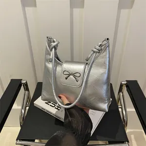 Sac à bandoulière argenté brillant avec nœud métallique et texture plissée élégante