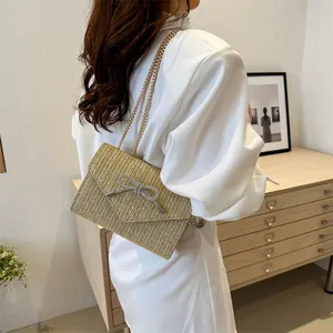 Sac bandoulière en paille tressée beige avec nœud en strass argenté et chaîne dorée