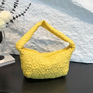 Bright yellow puffy shoulder bag with quilted 3D floral texture and zipper closure