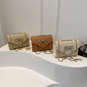 Sac bandoulière élégant en paille tressée avec boucle papillon et chaîne dorée d'été