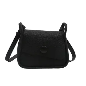 Minimalist black pebbled leather crossbody bag with flap and matte round button