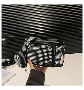 Détail du sac bandoulière noir avec strass argentés et large bandoulière tissée