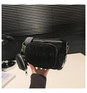 Détail du sac bandoulière noir avec strass brillants et un mini porte-monnaie rond