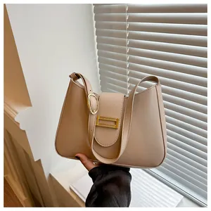 Beige faux leather shoulder bag with gold hardware and flap closure in soft light