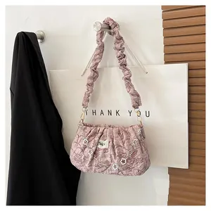 Detail of pink pleated cloud bag with silver flower chain and textured ruffle strap