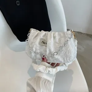 Chic white pleated cloud bag for women with silver chain and flower pendant detail